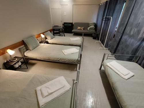 Habitación con 3 camas y sofá en Aliados City Drop Private Room, en Oporto