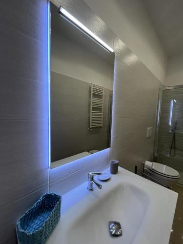 ein Badezimmer mit einem Waschbecken und einem großen Spiegel in der Unterkunft MAKI HOME in Portici