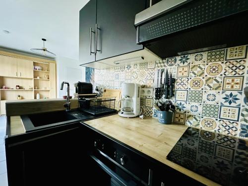 une cuisine avec un évier et un plan de travail dans l'établissement Charmant studio rénové, quartier Saint Michel, proche centre-ville - Les Sables, à Les Sables-dʼOlonne