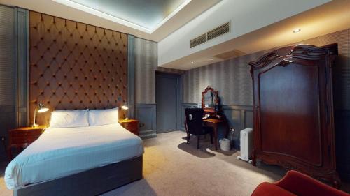 a bedroom with a bed and a desk and a piano at The Coal Exchange Hotel in Cardiff