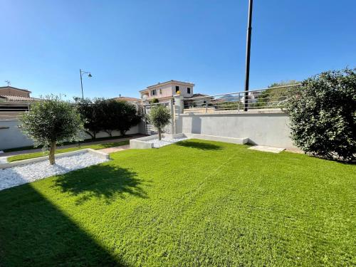 une cour avec de l'herbe verte et un bâtiment dans l'établissement Casa Fralia, à Olbia