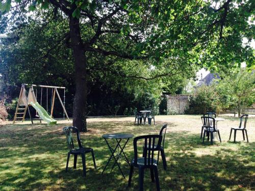 a group of chairs and tables under a tree at Château d'Avanton in Avanton