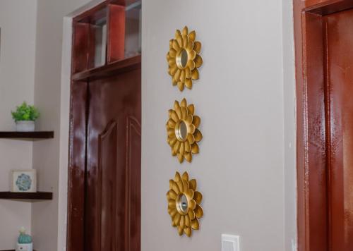 a pair of gold flowers on a wall next to a door at Sisi's Homes in Arusha