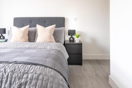 a bedroom with a bed and a nightstand with two lamps at Oasis at Hemel Hempstead in Hemel Hempstead