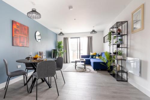 a living room with a table and a blue couch at Oasis at Hemel Hempstead in Hemel Hempstead