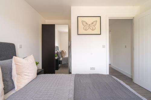a bedroom with a bed with a butterfly picture on the wall at Oasis at Hemel Hempstead in Hemel Hempstead