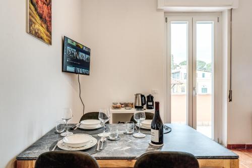 a table with glasses and a bottle of wine at V E N E R E Apartments in Rome