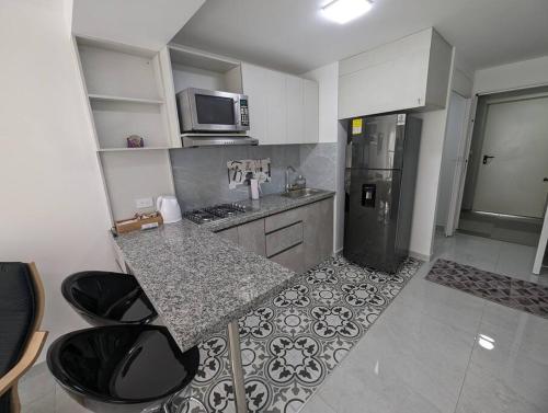 a small kitchen with a counter and a refrigerator at Lindo apartamento en el centro in Cali