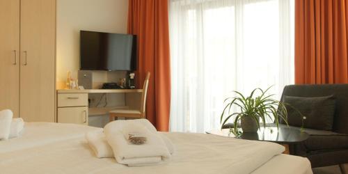 um quarto de hotel com uma cama e uma televisão em Müritzperle em Waren