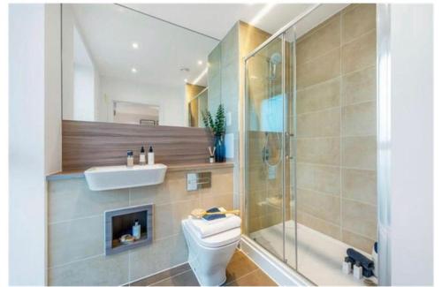 a bathroom with a toilet and a shower and a sink at UPPAMOST luxury home 3 in Dagenham