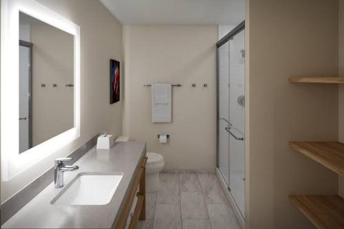 a bathroom with a sink and a toilet and a mirror at Candlewood Suites Sugarland Stafford in Houston