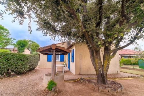 a tree in front of a building with a tree at Bourgarel in Vidauban