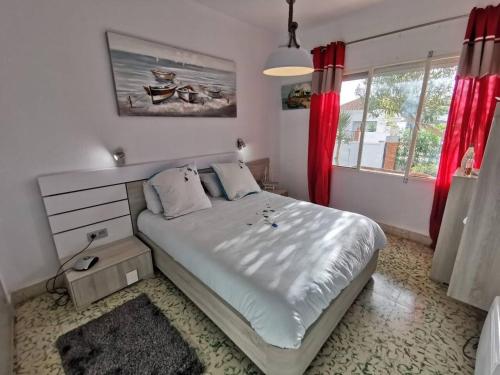 Schlafzimmer mit einem großen Bett und roten Vorhängen in der Unterkunft 3 bedrooms house at Alcanar 100 m away from the beach with terrace and wifi in Alcanar