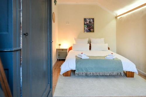 ein Schlafzimmer mit einem weißen Bett mit einer blauen Decke in der Unterkunft Belle 80 - beautiful renovated 1865 house in Eupen
