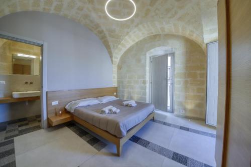 - une chambre avec un lit dans un mur en briques dans l'établissement Palazzo Fondo Vico - Affitti Brevi Italia, à Gravina in Puglia