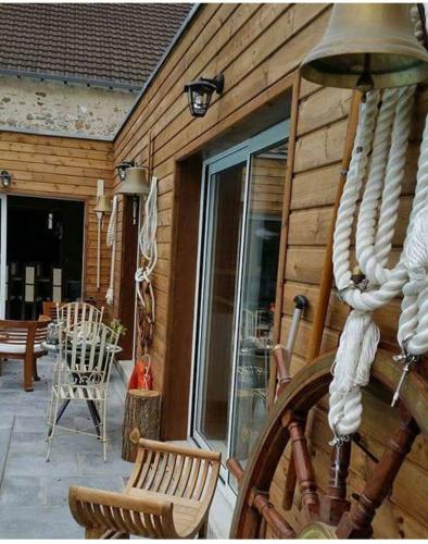a wooden house with a porch with a rocking chair at Propriete de 3 chambres avec piscine partagee jacuzzi et wifi a Chauffry in Chauffry