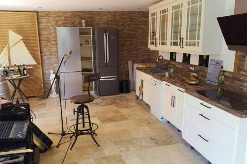a kitchen with a refrigerator and a table with a tripod at Propriete de 3 chambres avec piscine partagee jacuzzi et wifi a Chauffry in Chauffry