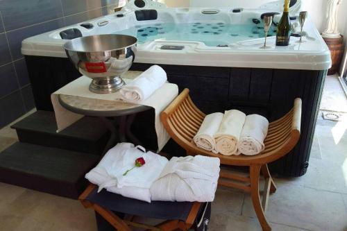 a bathroom with a sink and a tub with towels at Propriete de 3 chambres avec piscine partagee jacuzzi et wifi a Chauffry in Chauffry