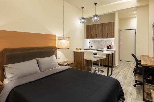 um quarto de hotel com uma cama e uma cozinha em GPX CLR GuestSuite No1 em Lárissa