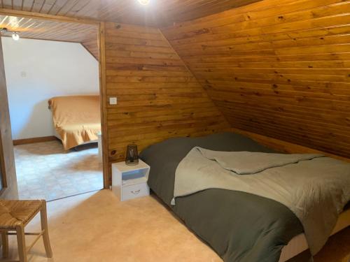 a bedroom with a bed in a wooden wall at Le Cantou in Castelnau-de-Mandailles