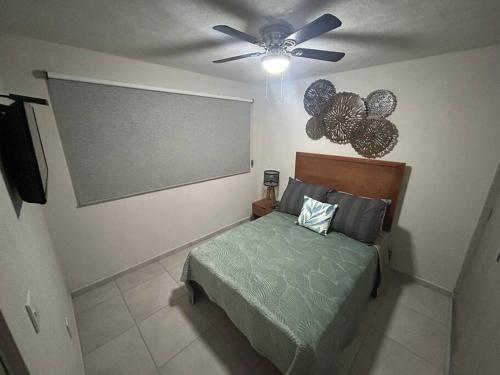 een slaapkamer met een bed en een plafondventilator bij Moderno y céntrico apto ideal para un descanso in Guadalajara