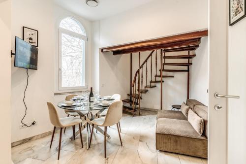 a dining room with a table and a couch at V E N E R E Apartments in Rome