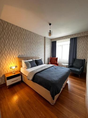 a bedroom with a large bed and a chair at SABİHA GOKCEN İSTANBUL HOUSES Airport in Istanbul