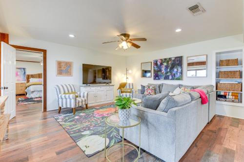 a living room with a gray couch and a ceiling fan at Lakefront Graford Home with Fire Pit and Private Dock! in Graford