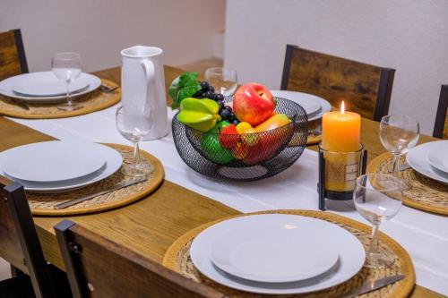 einen Tisch mit Tellern, eine Schale Obst und eine Kerze in der Unterkunft Charmant Appartement - Saint Paul de Vence Village in Saint-Paul-de-Vence