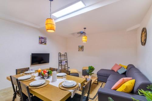 un salon avec une table et un canapé bleu dans l'établissement Charmant Appartement - Saint Paul de Vence Village, à Saint-Paul-de-Vence