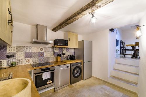 a kitchen with a stove and a dishwasher at Charmant Appartement - Saint Paul de Vence Village in Saint Paul de Vence