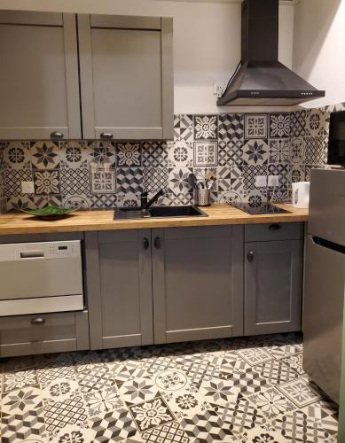 Il comprend une cuisine avec des placards gris et du carrelage. dans l'établissement T3 Provençal à la Ciotat, à La Ciotat