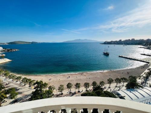 - une vue sur la plage avec un bateau dans l'eau dans l'établissement Monte Cristo Hotel with rooftop pool, à Saranda