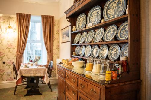 a dining room with plates on a wall at Gwrach Ynys Country Guest House in Harlech
