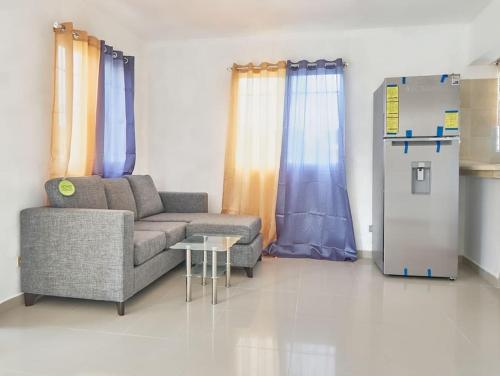 a living room with a couch and a refrigerator at Bright Charming Apartment in San Pedro de Macorís