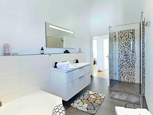 Baño blanco con lavabo y espejo en 3 bedrooms house with wifi at Bodman Ludwigshafen, en Bodman-Ludwigshafen