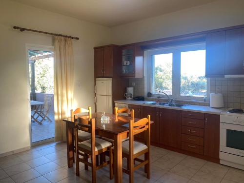 a kitchen with a table and chairs and a kitchen with a sink at Kioni Villas in Frangokastello