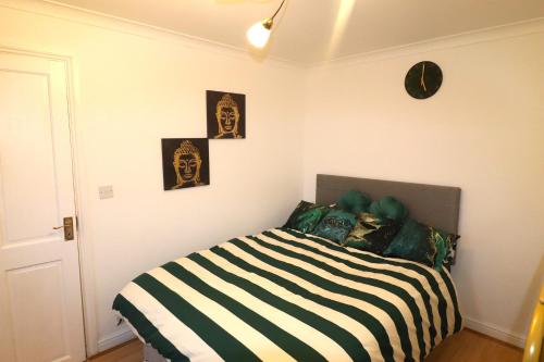 una camera da letto con un letto con una coperta a righe bianche e nere di Large Comfy Studio Flat, Next to Dartford Town Centre, Separate Kitchen, Wifi a Dartford