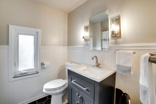 a bathroom with a toilet and a sink and a mirror at Penn Hills Home about 11 Mi to Pittsburgh 