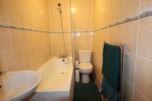 a bathroom with a tub and a toilet and a sink at Large Comfy Studio Flat, Next to Dartford Town Centre, Separate Kitchen, Wifi in Dartford