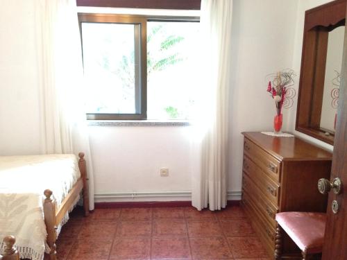 a bedroom with a bed and a window and a dresser at Casa Dos Cabecinhos in Paradamonte