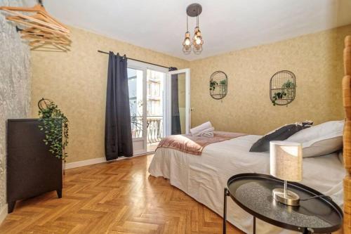 - une chambre avec un lit, une table et une fenêtre dans l'établissement VILLE ET VOLCANS - Grand gite proche centre-ville pour 24 personnes, à Clermont-Ferrand