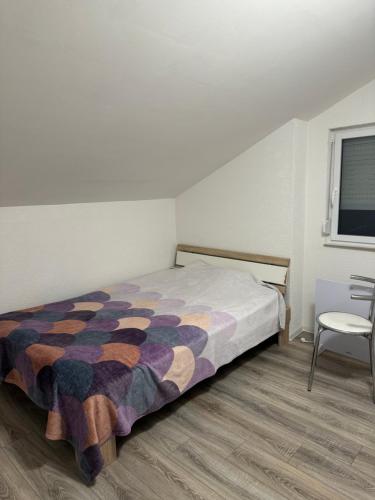 a bedroom with a bed and a chair and a window at Kuscheliges Einfamilienhaus in Lingenfeld