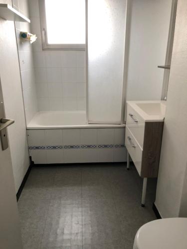 a bathroom with a tub and a toilet and a sink at LES BALCONS ROUGES - VUE MER in Sainte-Cécile-Plage