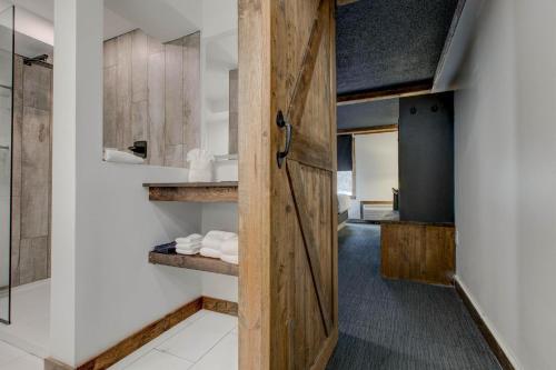 a bathroom with a wooden door in a room at Hotel Lex - Hotel and Conference Center in Lexington