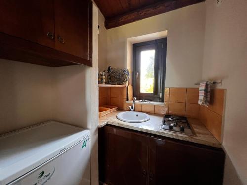 una pequeña cocina con fregadero y ventana en B&B La Casetta degli Aranci, en Agrigento