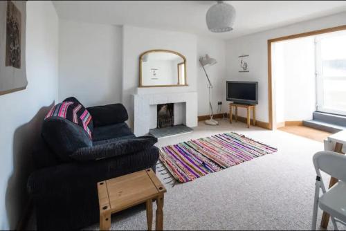 a living room with a chair and a fireplace at Spacious 2 Bedroom Apartment near Seafront in Penzance