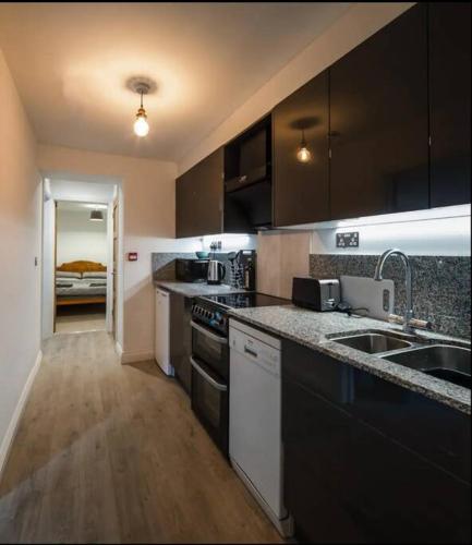a kitchen with a sink and a stove top oven at Spacious 2 Bedroom Apartment near Seafront in Penzance