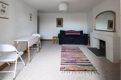 - un salon avec un canapé noir et une cheminée dans l'établissement Spacious 2 Bedroom Apartment near Seafront, à Penzance