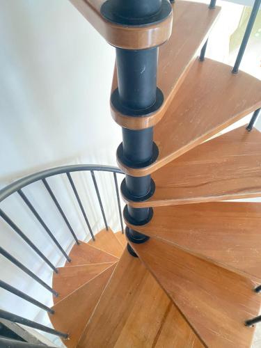 uma escada em espiral com piso preto numa escada de madeira em Euploia Apartment em Ischia